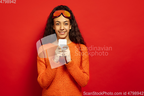 Image of African-american young woman\'s portrait in ski mask on red background