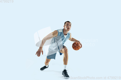 Image of Young caucasian basketball player against white studio background