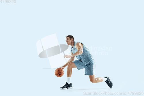 Image of Young caucasian basketball player against white studio background