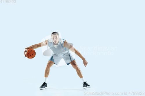 Image of Young caucasian basketball player against white studio background