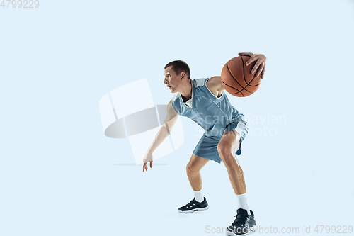 Image of Young caucasian basketball player against white studio background