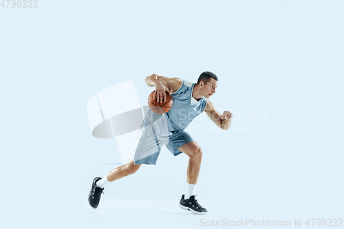 Image of Young caucasian basketball player against white studio background