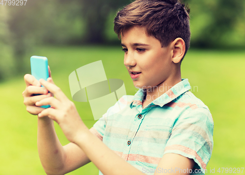 Image of boy with smartphone playing game in summer park