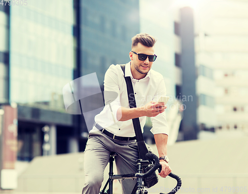 Image of man with bicycle and smartphone on city street