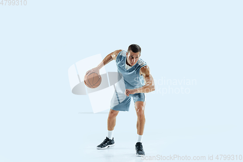 Image of Young caucasian basketball player against white studio background