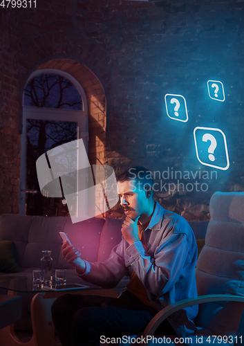 Image of Man using gadget and receive neon notifications at home at night