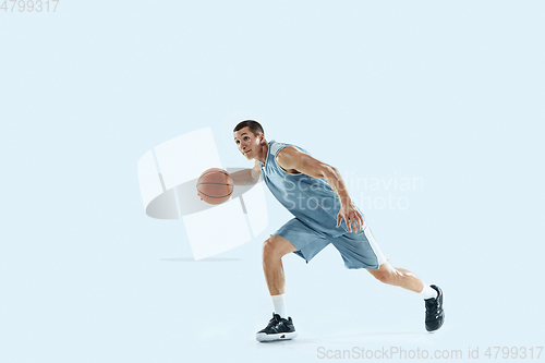 Image of Young caucasian basketball player against white studio background