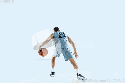 Image of Young caucasian basketball player against white studio background