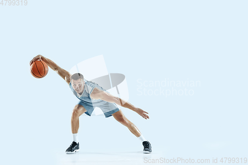 Image of Young caucasian basketball player against white studio background