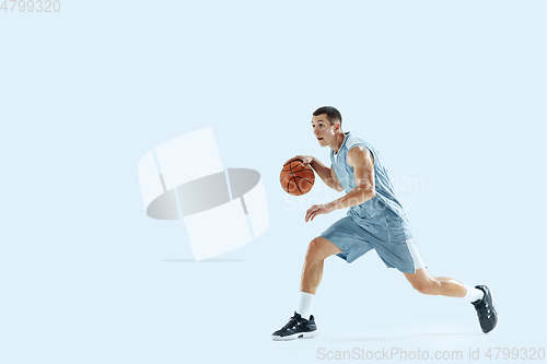 Image of Young caucasian basketball player against white studio background