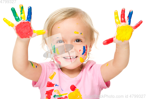 Image of Portrait of a cute little girl playing with paints