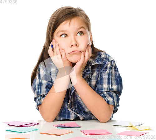 Image of Girl is writing on color stickers using pen