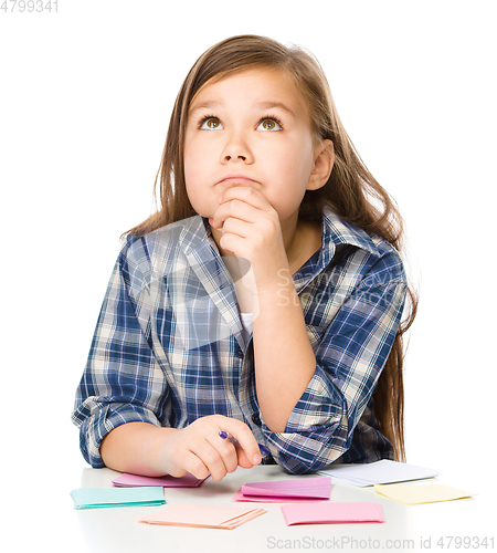 Image of Girl is writing on color stickers using pen