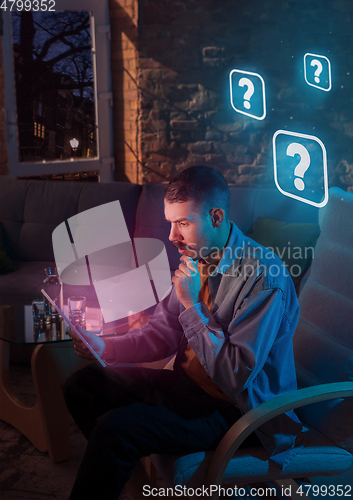 Image of Man using gadget and receive neon notifications at home at night