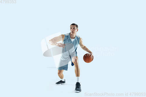 Image of Young caucasian basketball player against white studio background