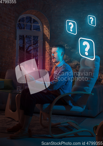 Image of Man using gadget and receive neon notifications at home at night