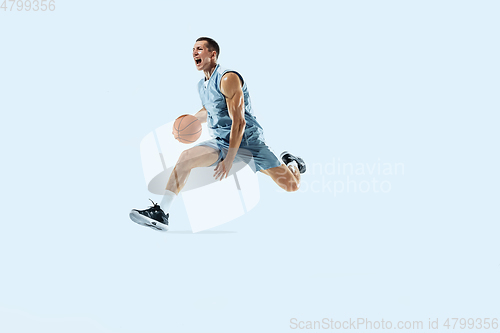 Image of Young caucasian basketball player against white studio background