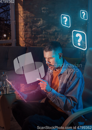 Image of Man using gadget and receive neon notifications at home at night