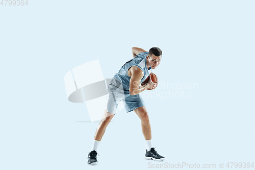 Image of Young caucasian basketball player against white studio background