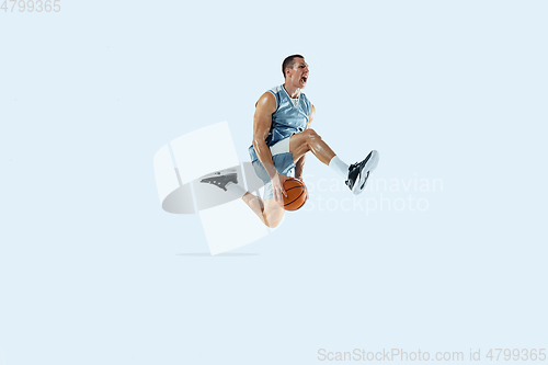 Image of Young caucasian basketball player against white studio background