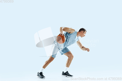 Image of Young caucasian basketball player against white studio background