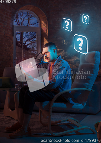 Image of Man using gadget and receive neon notifications at home at night