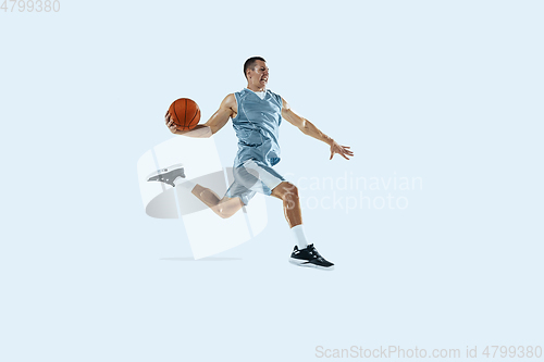 Image of Young caucasian basketball player against white studio background