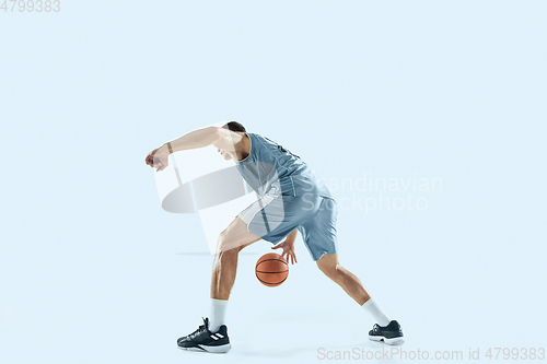 Image of Young caucasian basketball player against white studio background