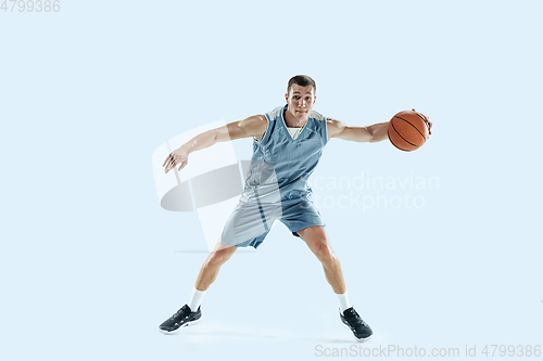 Image of Young caucasian basketball player against white studio background