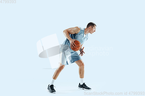 Image of Young caucasian basketball player against white studio background