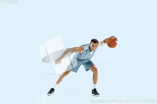 Image of Young caucasian basketball player against white studio background