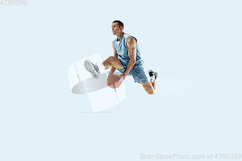 Image of Young caucasian basketball player against white studio background