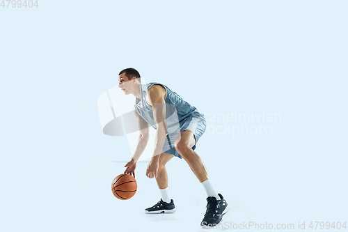 Image of Young caucasian basketball player against white studio background