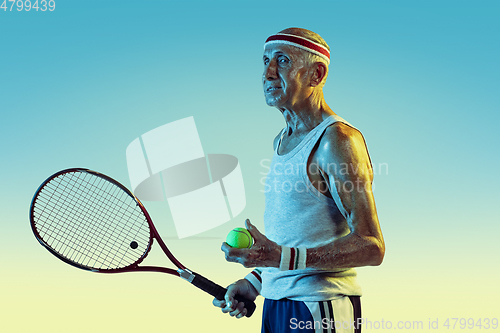 Image of Senior man playing tennis in sportwear on gradient background and neon light