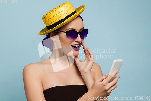 Image of Portrait of beautiful young woman with bright make-up isolated on blue studio background