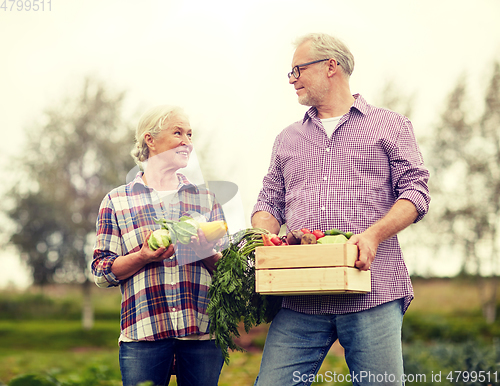 Image of senior couple with box of vegetables on farm