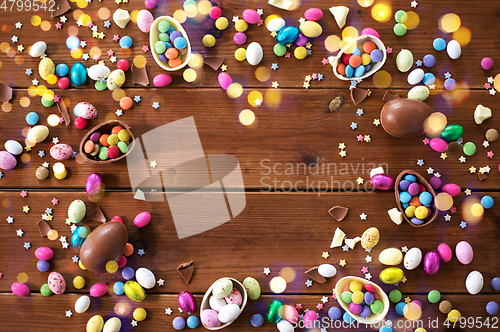 Image of chocolate eggs and candy drops on wooden table