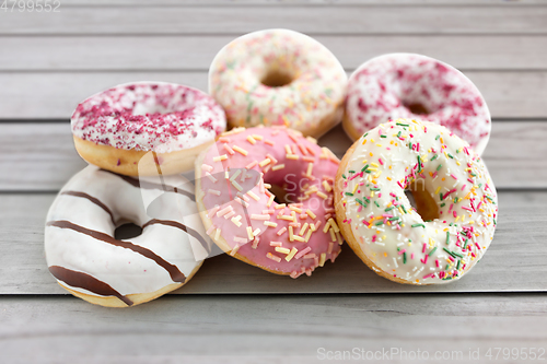 Image of close up of glazed donuts on wooden boards