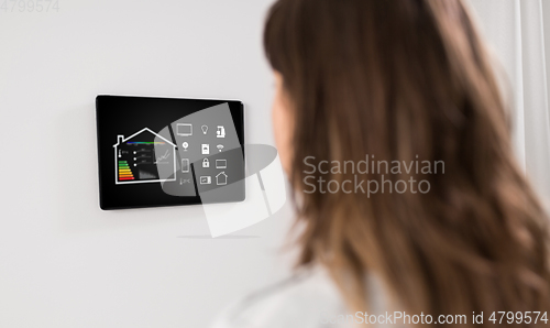 Image of woman looking at tablet computer at smart home