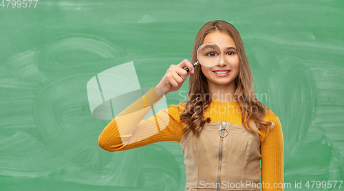 Image of student girl looking through magnifier at school