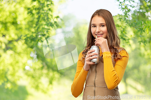 Image of happy teenage girl drinking soda from can