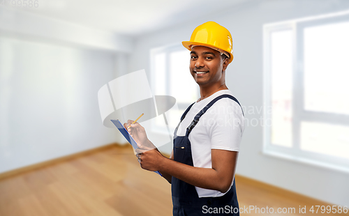 Image of happy builder in helmet with clipboard and pencil