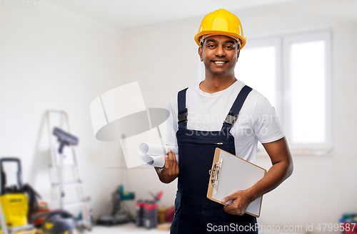 Image of happy indian builder with blueprint and clipboard