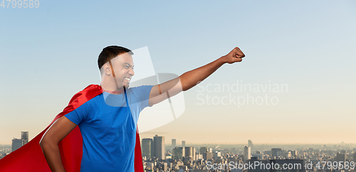 Image of indian man in superhero cape makes winning gesture