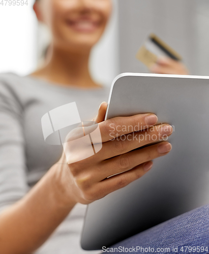 Image of woman with tablet pc and credit card at home