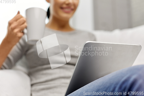 Image of close up of woman with tablet pc computer at home