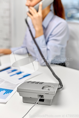 Image of businesswoman calling on desk phone at office