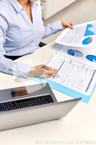 Image of businesswoman with papers working at office