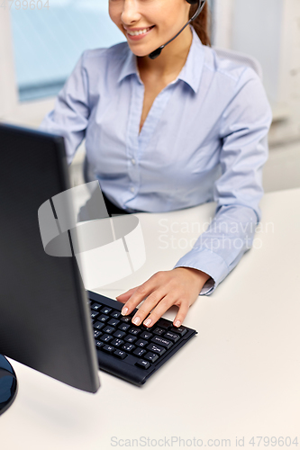 Image of businesswoman with headset and computer at office