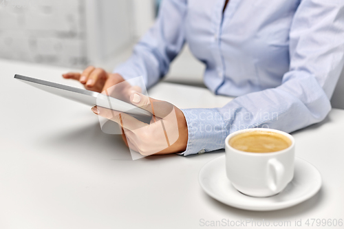 Image of businesswoman with tablet pc and coffee at office